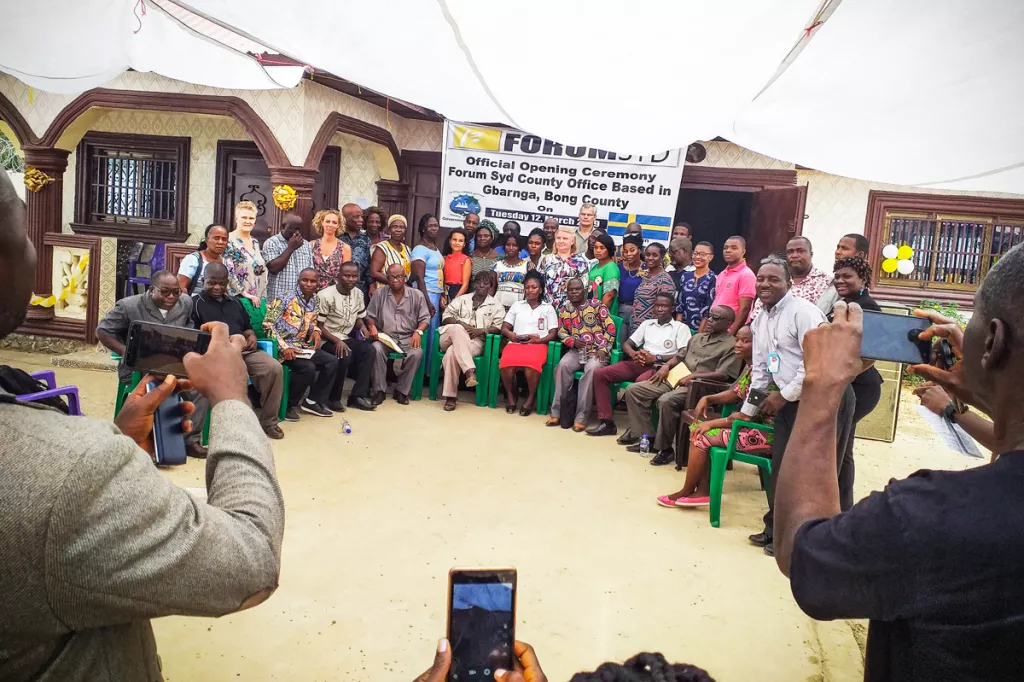 Group photo of the 40 attendees, several phones are also trying to capture the group.