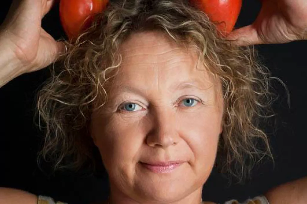 Irina Sukhy posing while holding two tomatoes in her hair. 