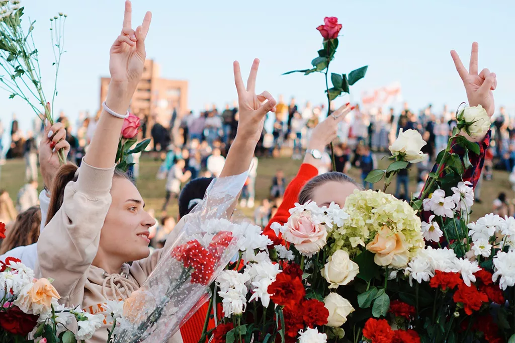 Women dressed in white protesting with flowers in their hands