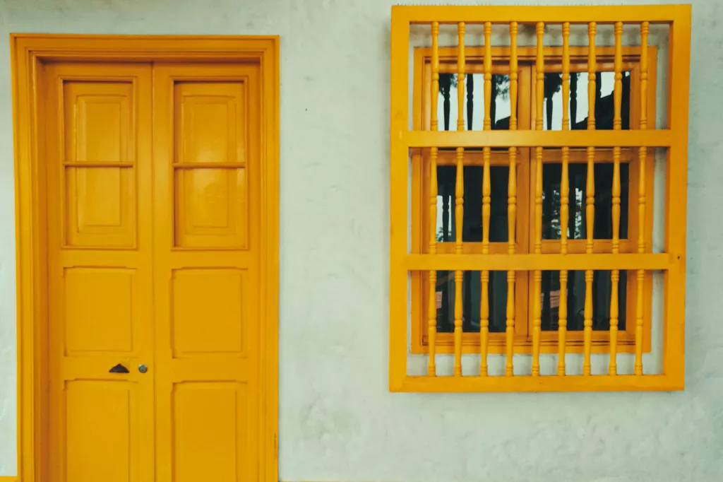Closed yellow door with bars on the window