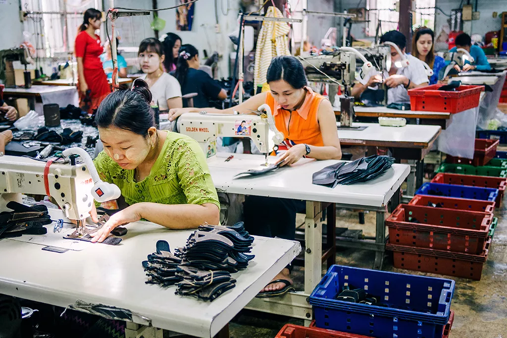 Burmesiska migrantarbetare syr läderskor i en fabrik i Thailand.