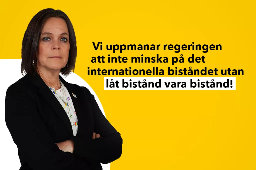 Anna står med armarna i kors och tittar in i kameran. Hon har en svart kavaj på sig. Text i bild: Vi uppmanar regeringen att inte minska på det internationella biståndet utan låt bistånd vara bistånd!