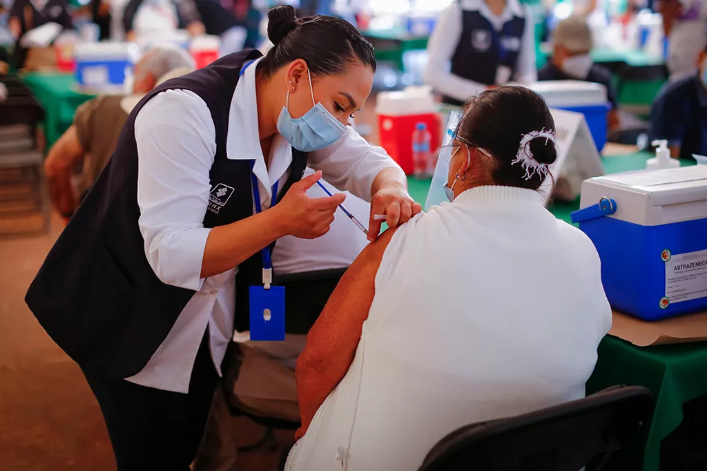 En sjuksköterska i Mexiko ger Covid-19 vaccin till en pensionär.