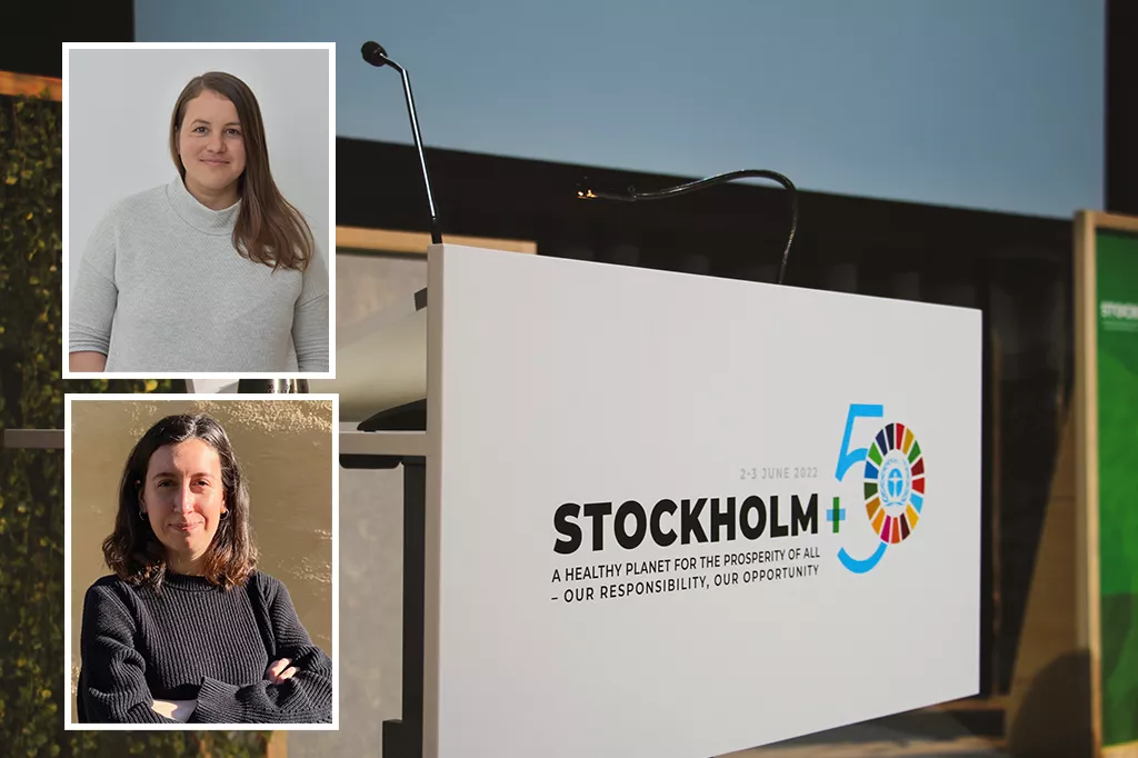 Bild på Liinu i grå tröja och Evelina i svart tröja. I bakgrunden syns Stockholm+50 konferensens logotyp på ett podium.