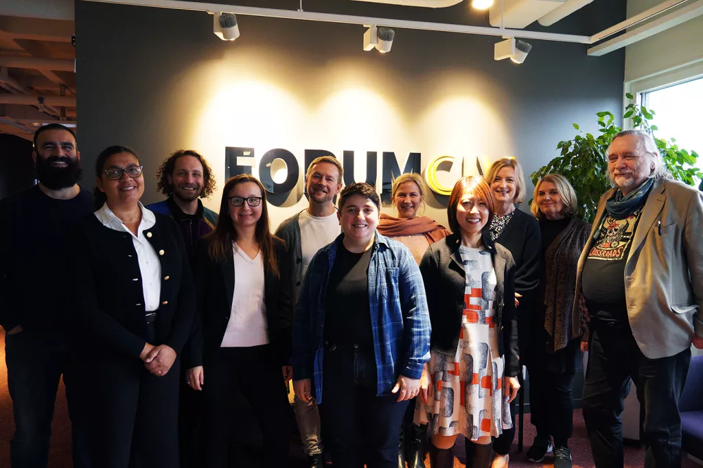 People from the network are standing in front of a gray wall with ForumCiv's logotype.