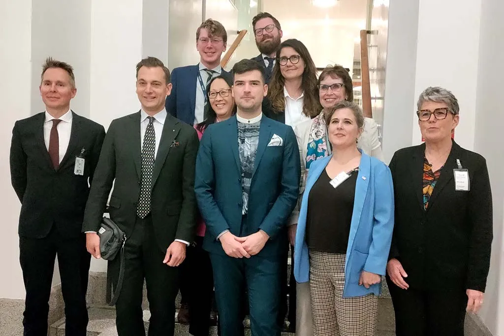 Panellister poserar för ett gruppfoto i Riksdagen.