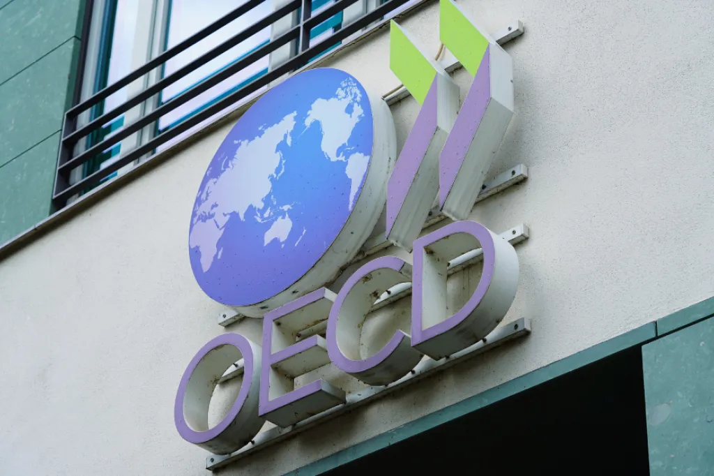 OECDs globe logo in color on a beige building wall