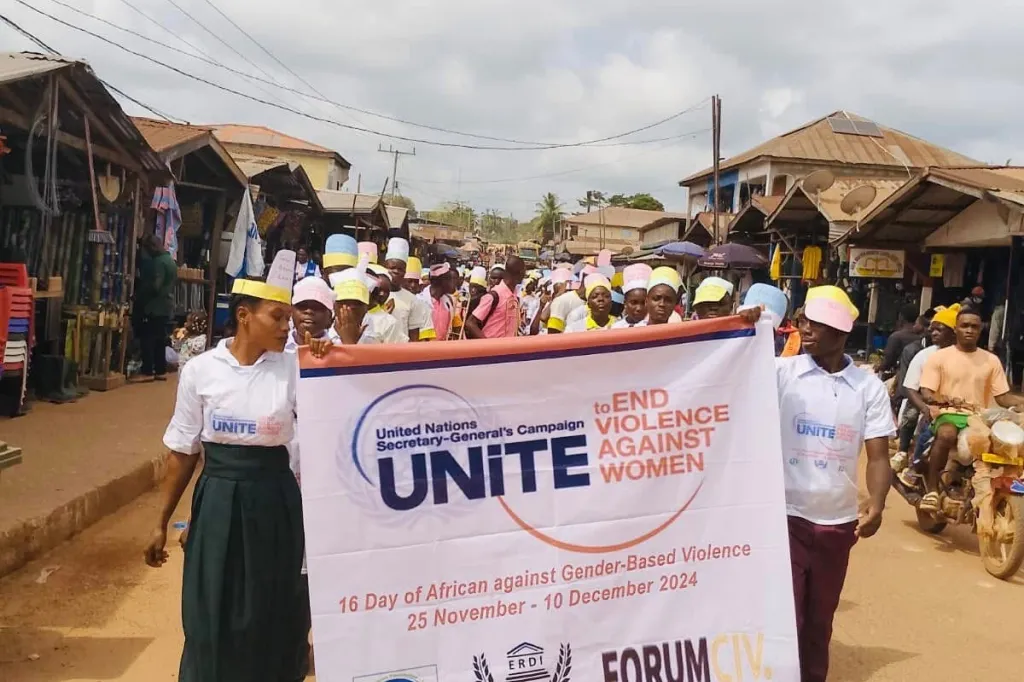 People marching with a banner that says unite against violence against women and girls