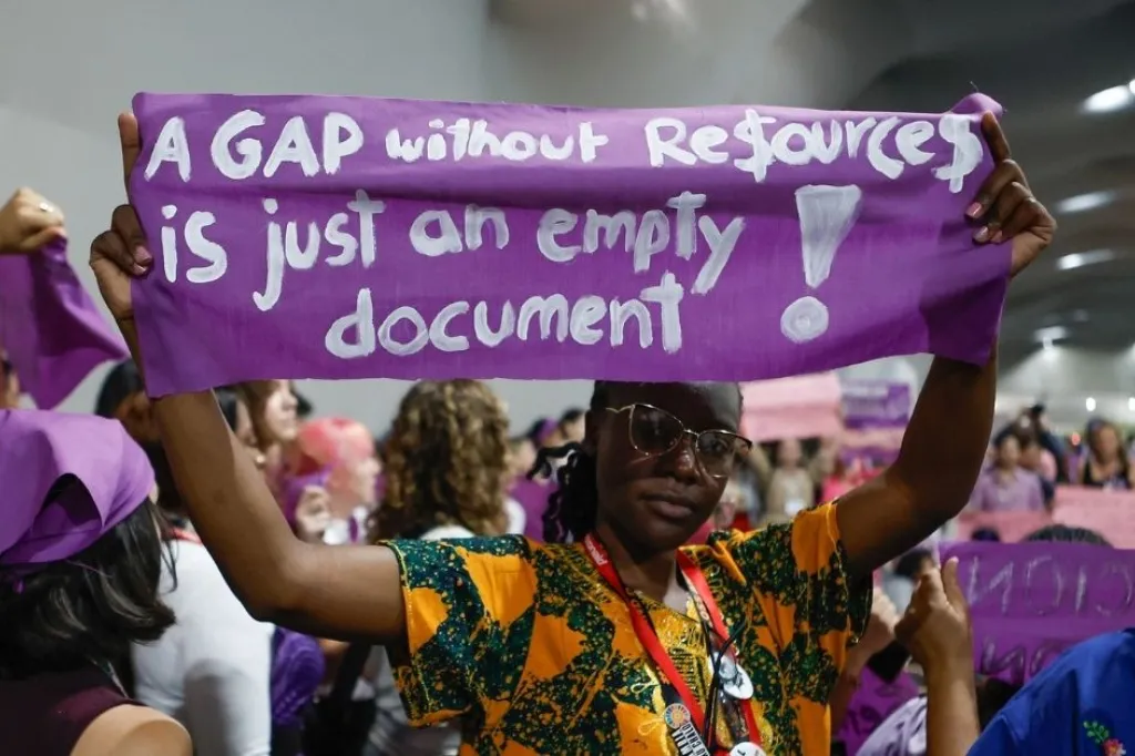 Women at COP30 holding banner with the text A gap without resources is just an empty document.