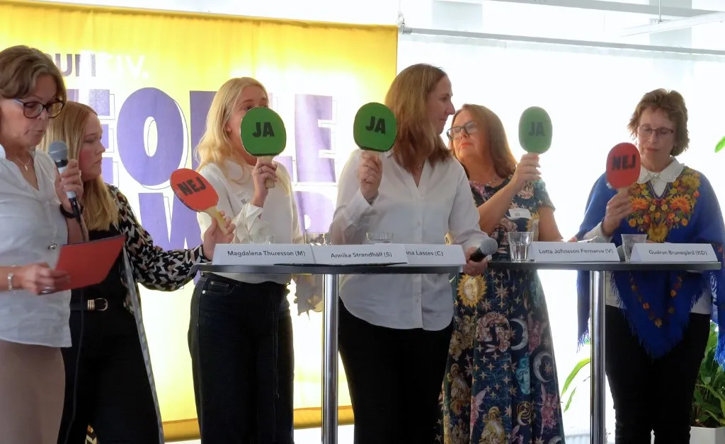 Socialdemokraterna, Centerpartiet och Vänsterpartiet håller upp gröna skyltar som säger ja. Kristdemokraterna och Moderaterna håller upp röda skyltar som säger nej. säger