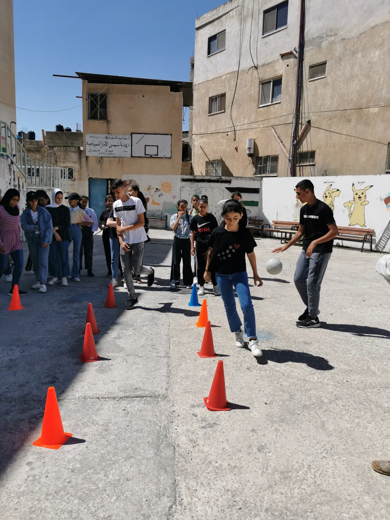 Kids playing football between orange cones 