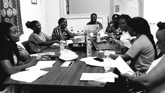 Representanter från organisationerna som upptäckte korruption i Bong County, Liberia, sitter vid ett bord.