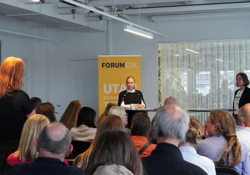 Diana Janse tar emot en fråga från en av ForumCivs medlemmar. Bredvid henne står Anna Stenvinkel generalsekreterare ForumCiv.