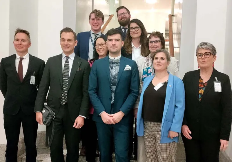 Panellister poserar för ett gruppfoto i Riksdagen.