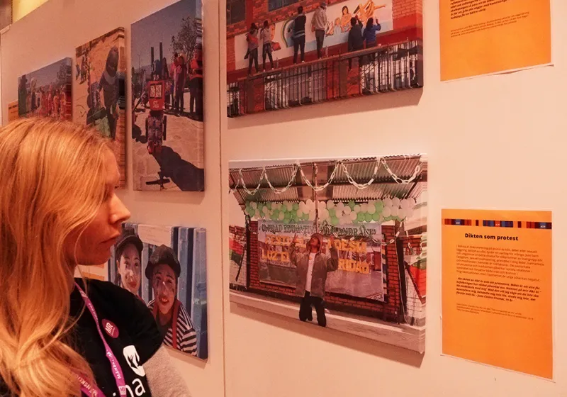 Kvinna tittar på bilder från en utställning på MR-dagarna i Örebro.