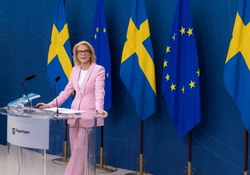 Finansminister Elisabeth Svantesson presenterar vårbudgeten vid en pressträff iklädd en rosa kostym.
