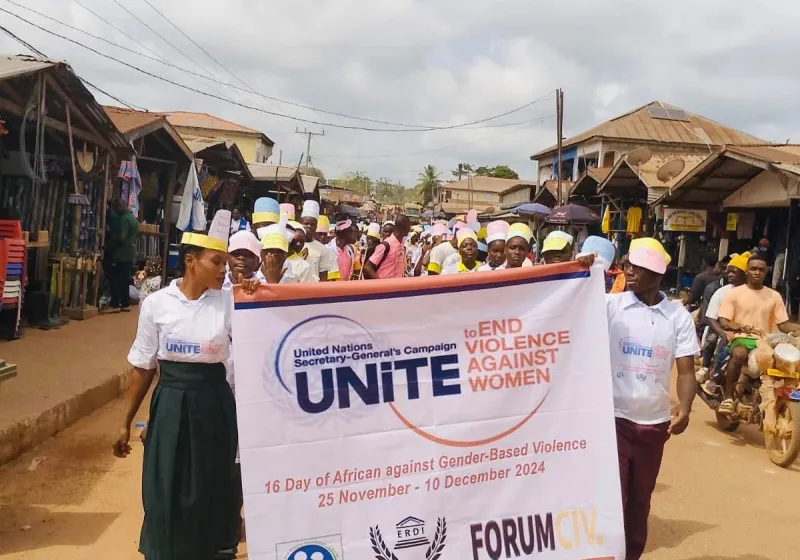 People marching with a banner that says unite against violence against women and girls