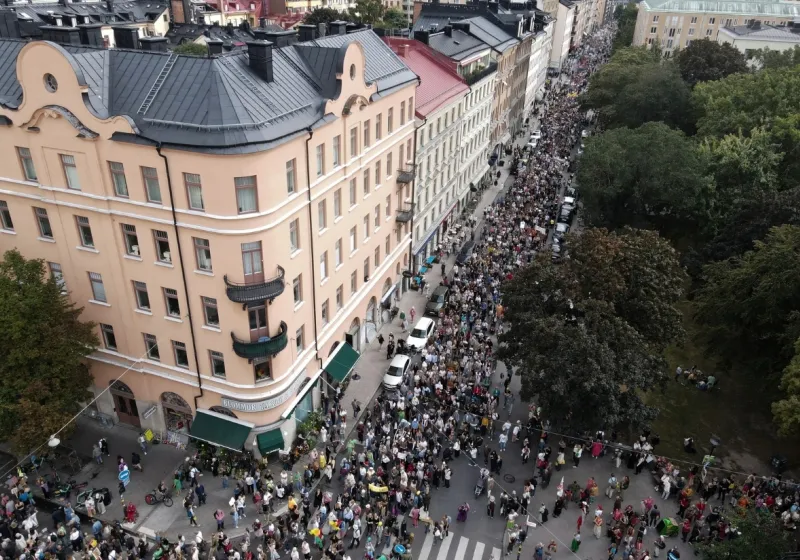 Flygfoto över människor som går i demonstrationståg i Stockholm.
