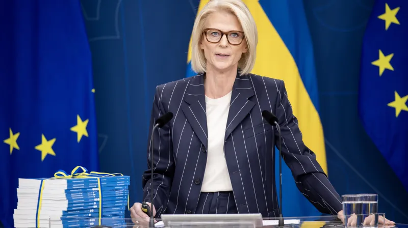 Elisabeth Svantesson står framför en hög med budgetpropositionen.