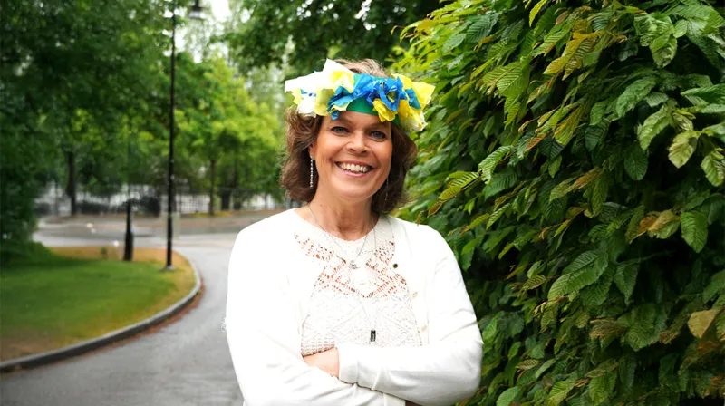 Anna stenvinkel ler mot kameran med en midsommarkrans i papper på huvudet.