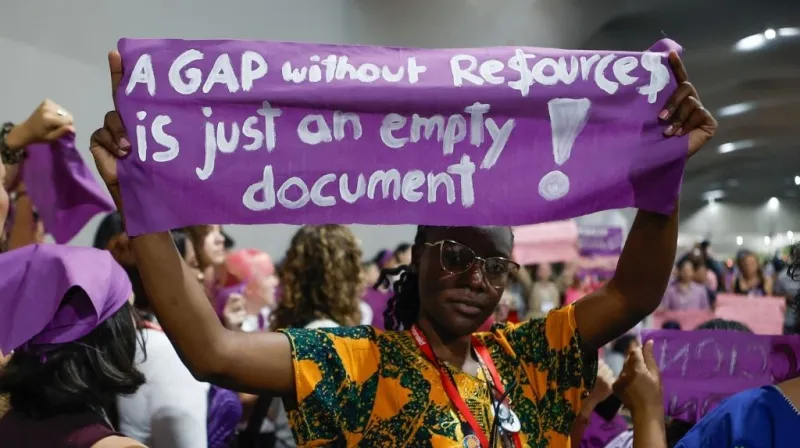 Women at COP30 holding banner with the text A gap without resources is just an empty document.