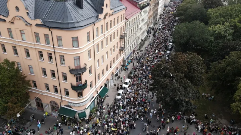 Flygfoto över människor som går i demonstrationståg i Stockholm.